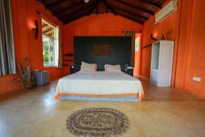 a bedroom with a large bed with orange walls at Singhe House in Dickwella