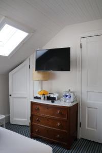 a bedroom with a dresser with a tv on the wall at The Star Inn in Cape May