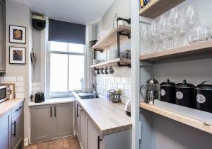 a kitchen with white cabinets and a counter top at The Neuk in North Berwick