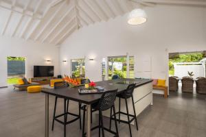 a kitchen and living room with a table and chairs at Villa Girafe Bleue 2 Suites Pool & Garden in Gourbeyre