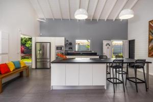 a kitchen with a counter and chairs in a room at Villa Girafe Bleue 2 Suites Pool & Garden in Gourbeyre