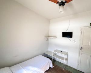 a bedroom with a bed and a tv on the wall at Elite Economy Hotel - Banheiro Compartilhado in Pará de Minas
