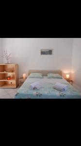 a bedroom with a bed with two pillows on it at podskoj apartment in Saplunara