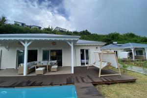 a house with a wooden deck and a pool at Villa Duna 2 Bedrooms Pool & Tropical Atmosphere in Sainte-Anne