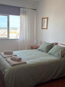 a bedroom with a large bed with towels on it at T2 A 150 m de la plage in Armação de Pêra