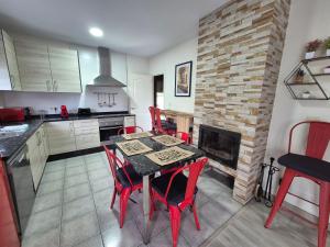 eine Küche mit Tisch und Stühlen und einem Kamin in der Unterkunft Checoira in Ourense