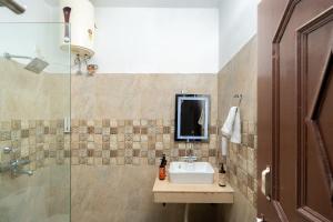 a bathroom with a sink and a glass shower at Adviga by The StayCationer in Dehradun +46 photos