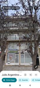 ein Gebäude mit einem Baum davor in der Unterkunft Boulevard Roca in Trelew