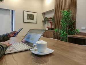 a person sitting at a table with a laptop and a cup of coffee at Travelers Condominio Plenitud in Bogotá