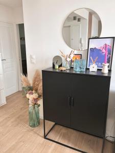 a black dresser in a room with a mirror at Appartement Cosy Beauvais in Beauvais +18 photos