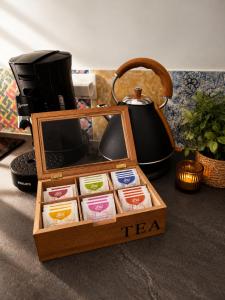 a wooden box with tea packets in front of a coffee maker at Maisonnette de charme A 5 min du Parc PUYDUFOU in Les Épesses