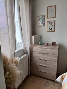a bedroom with a dresser and a window at Appartement Cosy Beauvais in Beauvais