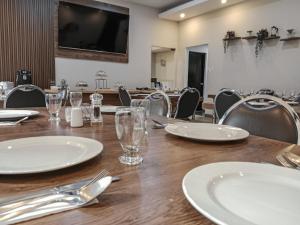 a wooden table with white plates and glasses on it at Travelers Condominio Plenitud in Bogotá +42 photos
