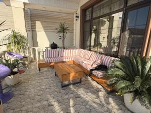 a couch on a patio with a table and plants at Seaside Luxe Villa in Bilgah