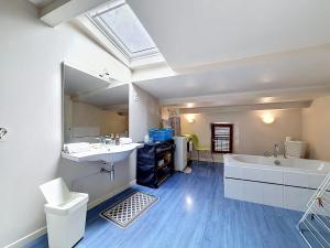 a bathroom with a tub and a sink and a mirror at Maison de bourg - Charmante & Authentique , PLAUZAT in Plauzat