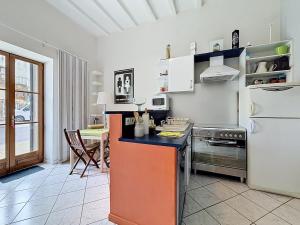 a kitchen with a refrigerator and a table in it at Maison de bourg - Charmante & Authentique , PLAUZAT in Plauzat +4 photos