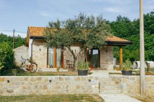 a stone house with a tree in front of it at Museum Draginë-Guest House in Sukobin