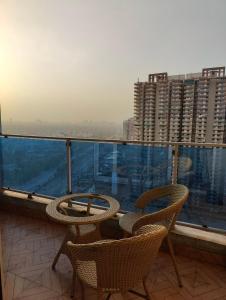 a balcony with two chairs and a view of a city at Arista Stay I Studio Room I Sec-4 Greater Noida in Noida