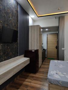 a room with a bed and a flat screen tv at Arista Stay I Studio Room I Sec-4 Greater Noida in Noida