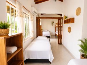 a room with two beds and two windows at Hotel Manglares in Capurganá