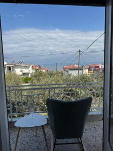 a chair sitting on a balcony with a view of the ocean at Metani Residence in Skala Sotiros