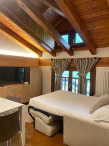 a bedroom with a large bed in a room with wooden ceilings at Maison Poluc - Le Petit Chalet in Champoluc
