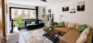 a living room with a couch and a table at FeWo Prinzregent - große Zentrale Wohnung, ideal für Gruppen & Familien in Bad Kissingen