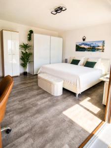 a bedroom with a large white bed and a chair at FeWo Prinzregent - große Zentrale Wohnung, ideal für Gruppen & Familien in Bad Kissingen