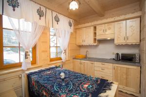 a kitchen with wooden cabinets and a table with a blanket at Domek Góralski Suche in Suche