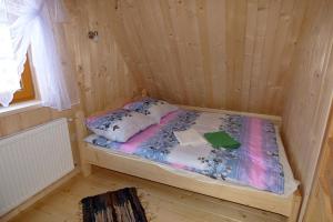 a small room with a bed in a wooden cabin at Domek Góralski Suche in Suche