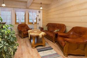 a living room with leather furniture and a table at Domek Góralski Suche in Suche +1 photo