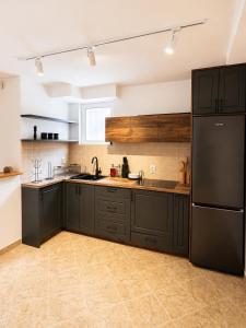 a kitchen with black cabinets and a black refrigerator at Casa Matthias in Kavadarci