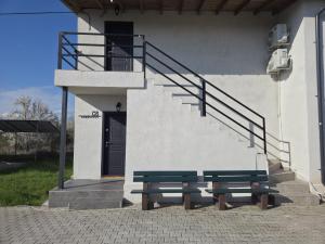 two benches in front of a building with a staircase at Grayscale Apartments in Venus