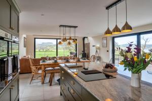 a kitchen with a large island with a table and a dining room at Finest Retreats - Cae Rhug in Llanuwchllyn