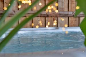 a swimming pool with lights in a wooden fence at Finest Retreats - Cae Rhug in Llanuwchllyn