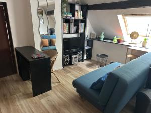 ein Wohnzimmer mit einem blauen Sofa und einem Tisch in der Unterkunft Envoz-Zen in Héron