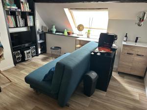 ein Wohnzimmer mit einer blauen Couch und eine Küche in der Unterkunft Envoz-Zen in Héron
