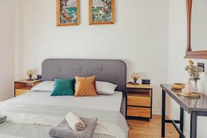 a bedroom with a bed with colorful pillows on it at Museum Draginë-Guest House in Sukobin