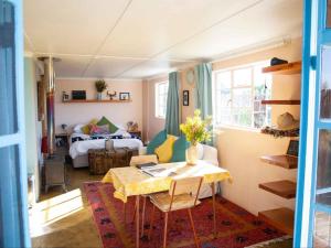 a room with a table and a bedroom with a bed at Starry Starry Night - Route 62 in Montagu