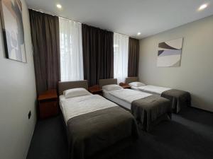a hotel room with three beds and a window at Zatyshok Затишок in Rokytne