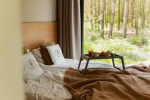 a bed with a table on it next to a window at w lesie in Skrwilno
