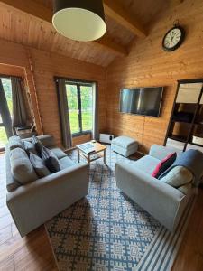 a living room with two couches and a flat screen tv at Modern Summerhouse in Lymington