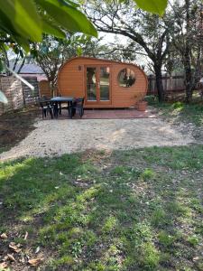a small wooden cabin with a table and chairs at Insolite hobbit in Saint-André-dʼAllas +7 photos