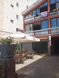 a patio with chairs and umbrellas in front of a building at Kolovic Susanj in Bar