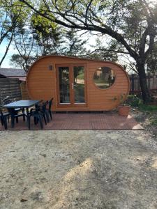 a tiny house with a picnic table and a tree at Insolite hobbit in Saint-André-dʼAllas