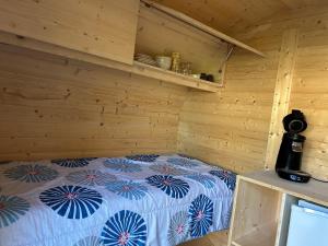 a room with a bed in a wooden cabin at Insolite hobbit in Saint-André-dʼAllas
