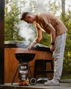 a man is cooking food in a grill at w lesie in Skrwilno