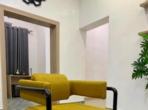 a yellow chair in a room with a mirror at Uzzy Homes in Lagos