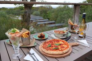 a table with a pizza and french fries and wine at Castle Brake Holiday Park in Woodbury +11 photos