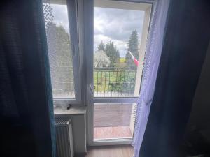 an open window with a view of a balcony at Gospodarstwo Agroturystyczne E K Szabowscy in Jeżewo